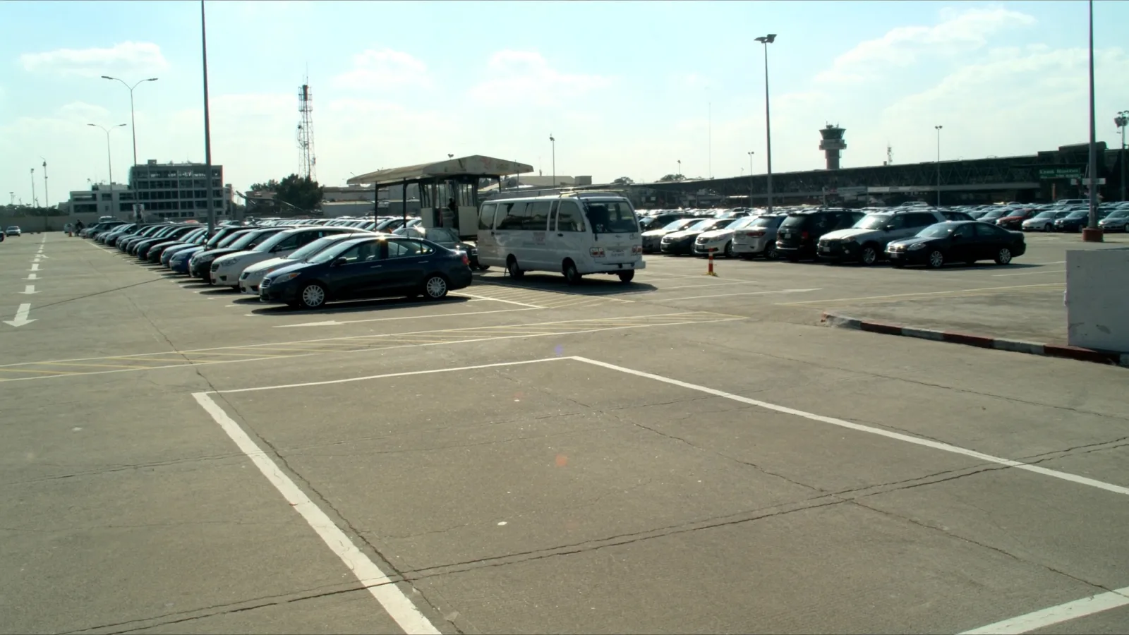 bolsão de estacionamento descoberto ao lado do aeroporto com van de traslado esperando passageiros